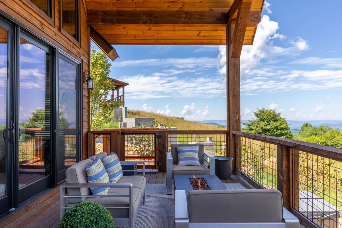 This image showcases a cozy outdoor seating area arranged around a fire pit, set against the backdrop of sweeping mountain views. Comfortable chairs invite guests to relax and enjoy the tranquility of nature, with the fire pit serving as a focal point for evening gatherings. The landscape emphasizes the property's close connection to the surrounding wilderness, ideal for stargazing or unwinding after a day on the trails.
