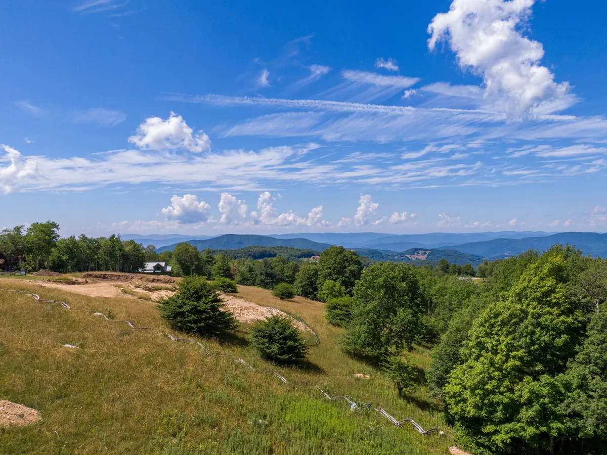 A wide, breathtaking vista of rolling hills, distant mountains, and expansive sky, this view invites families to imagine hiking, playing, or simply experiencing the outdoors. The lush greenery and tranquil scene evoke a sense of adventure and exploration in nature.