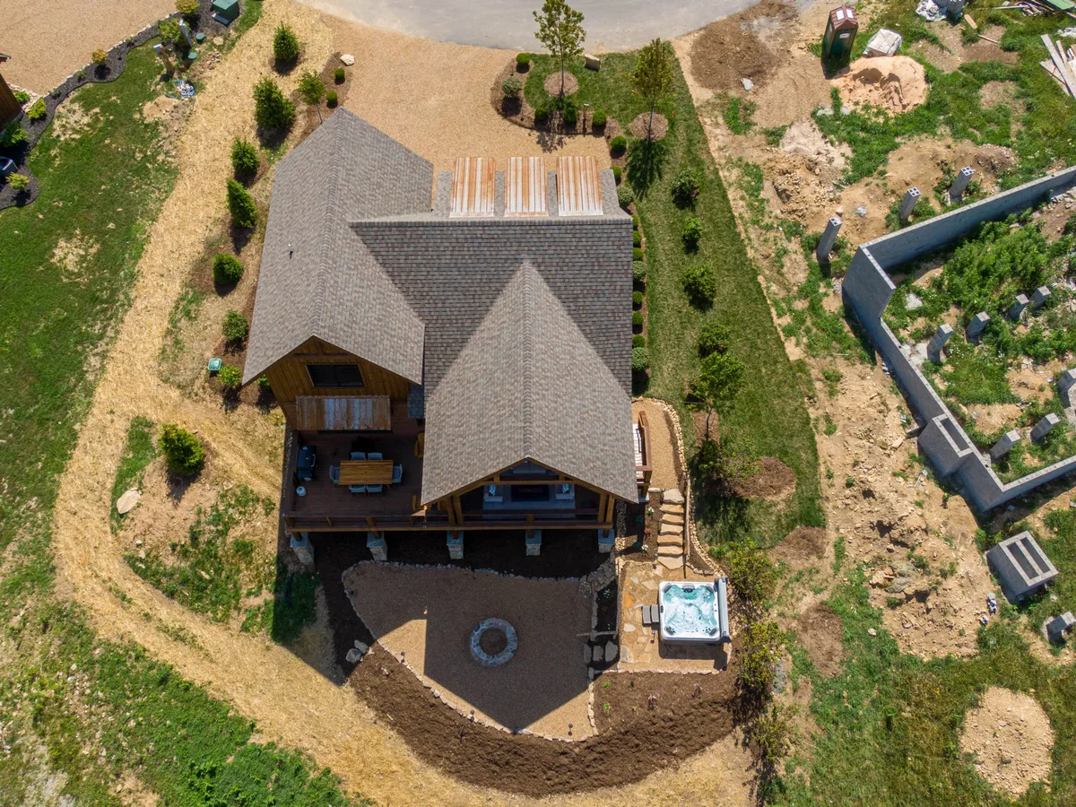 This image offers a serene exterior view of the property, highlighting the inviting hot tub nestled in a landscaped yard. The home itself is visible, with well-kept grounds and outdoor relaxation spaces that capture the essence of luxury leisure and connection to nature.