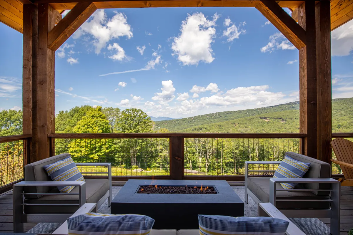 A cozy outdoor seating area surrounds a fire pit, framed by mountain vistas and an expansive sky. The setting is perfect for evening gatherings, stargazing, or simply enjoying the peaceful atmosphere after a day of adventure.
